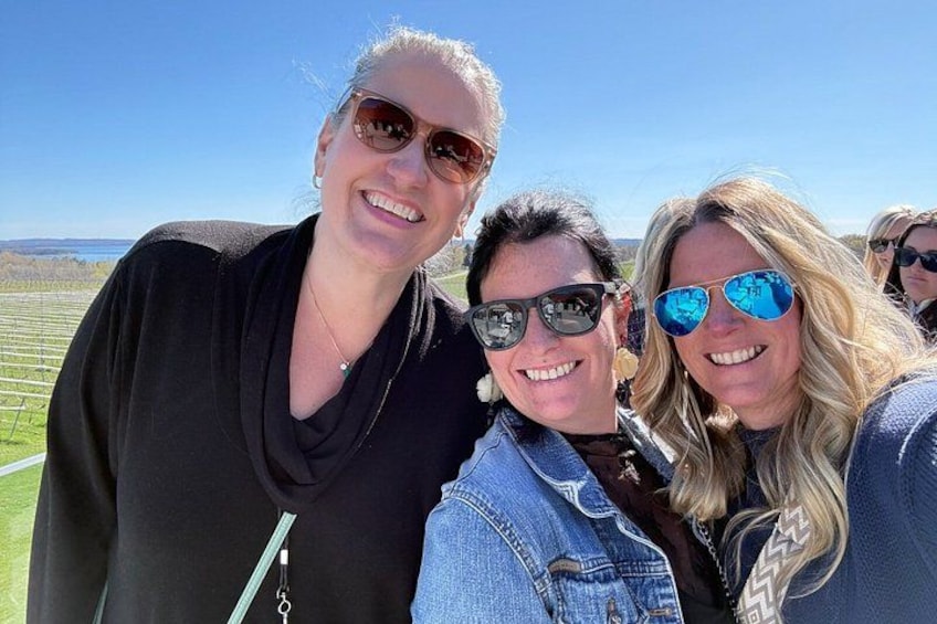 Three people outdoors with a clear sky and a field in the background. 3