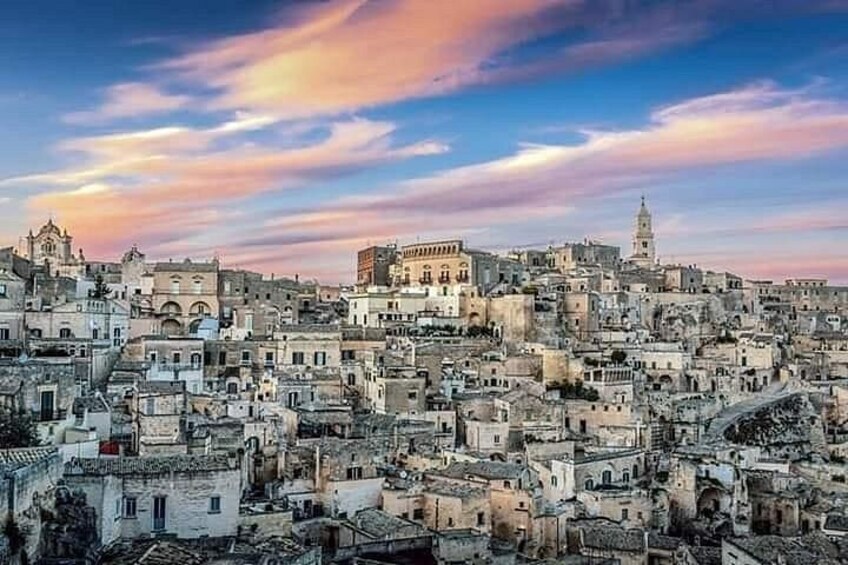 A densely packed urban landscape with historic architecture, a prominent church, and a tower. 2