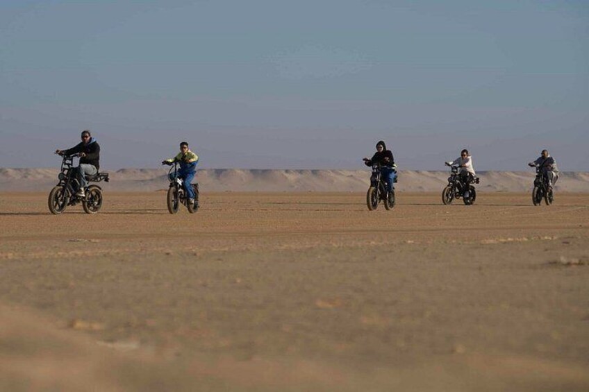 Four people riding motorcycles in a desert landscape. 2