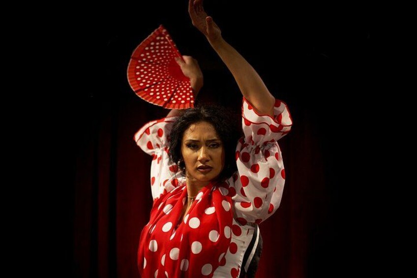 A person in a polka-dotted dress with a red fan. 5