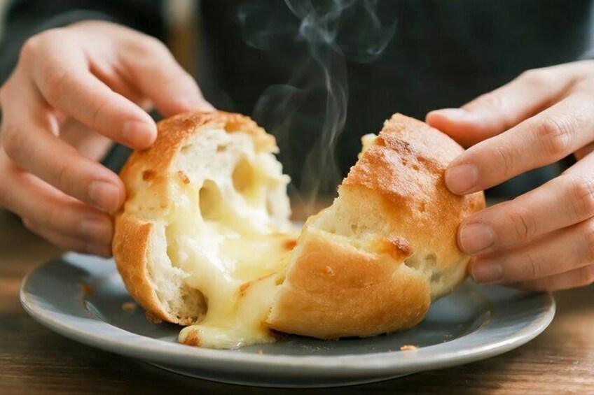 Una persona tiene un panino con formaggio su un piatto. 4