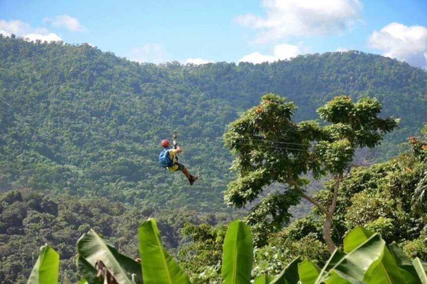 A person bungee jumping with a forested mountain in the background. 5