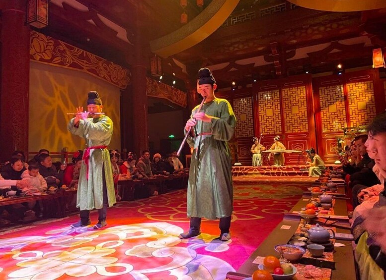 A traditional Chinese opera performance with performers in costume and an audience seated at tables. 3