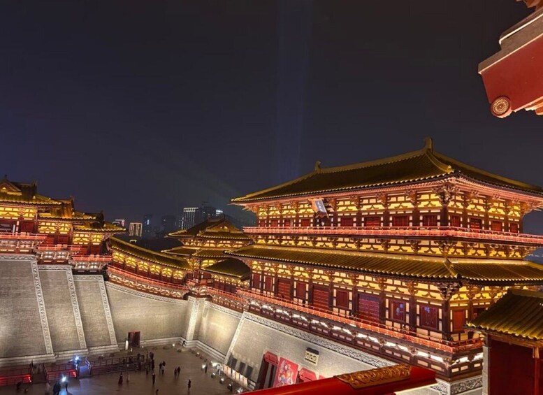 A traditional Chinese building with illuminated golden roofs and walls, surrounded by a large open courtyard. 5