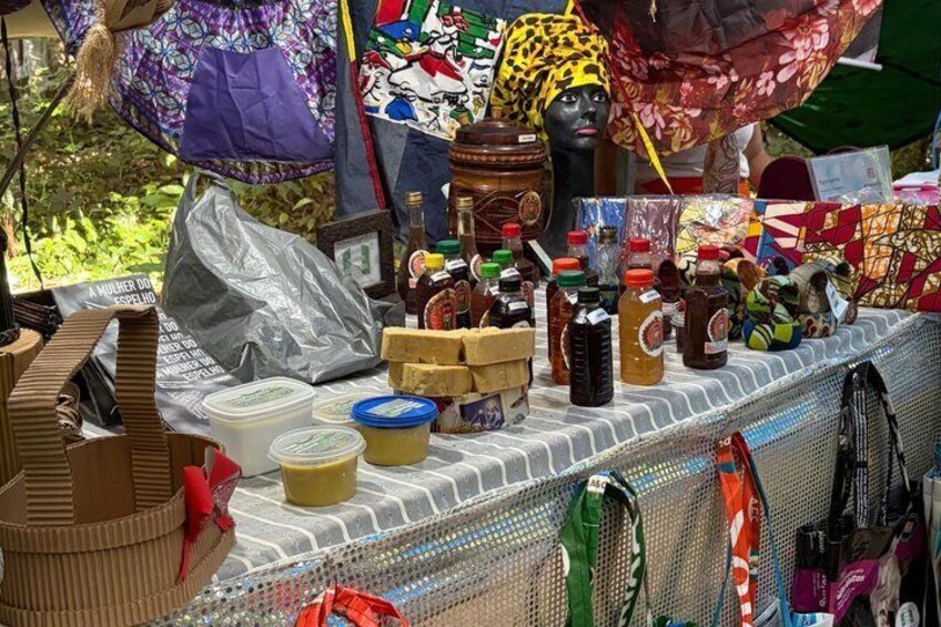 A market stall with various food items, including jars of honey and honeycomb, and a mannequin head. 2
