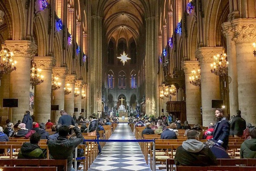 Interno di una cattedrale con file di bancali, una navata centrale e un grande lampadario. 2
