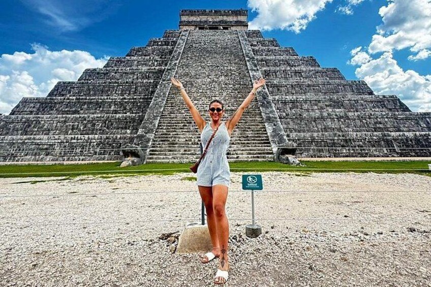A large pyramid structure with a person standing in front of it. 1