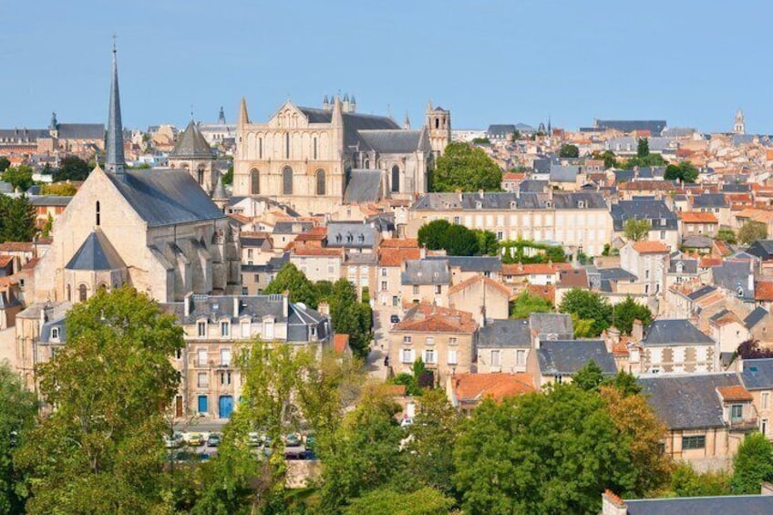 A historic cityscape with prominent cathedral spires and dense residential buildings. 2
