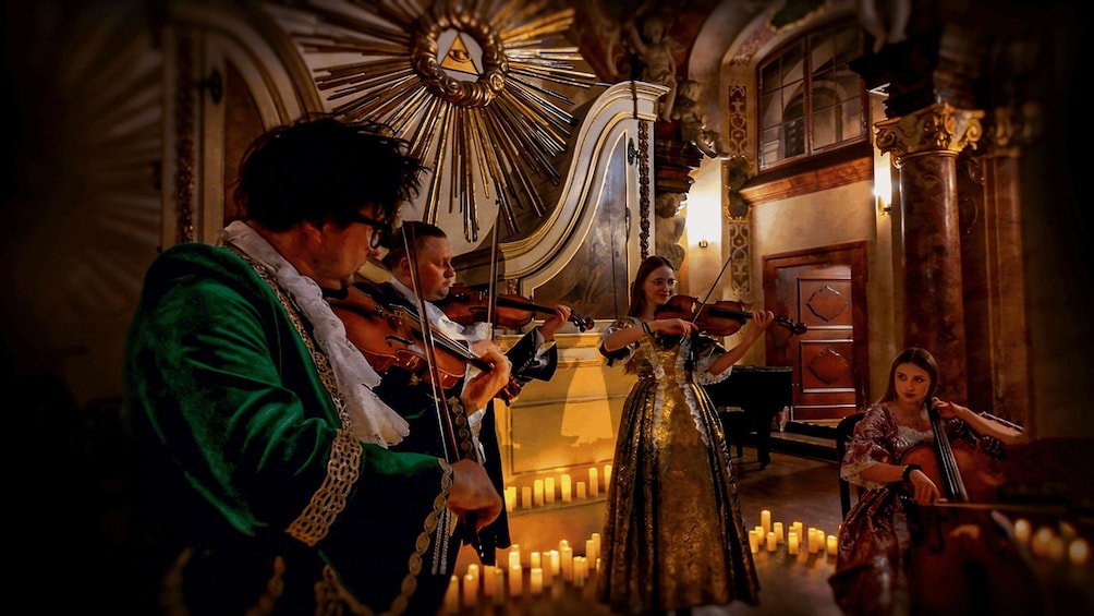 A group of musicians performing in a grand, ornately decorated room with candles. 4