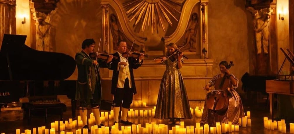 A classical music performance with musicians on stage surrounded by candles. 1