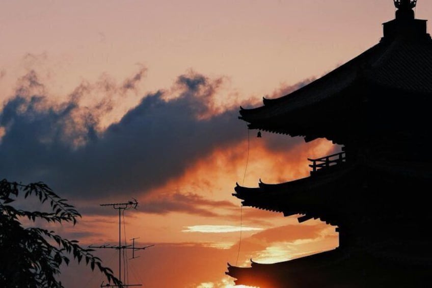 Una pagoda tradicional silueteada contra un cielo al atardecer. 3