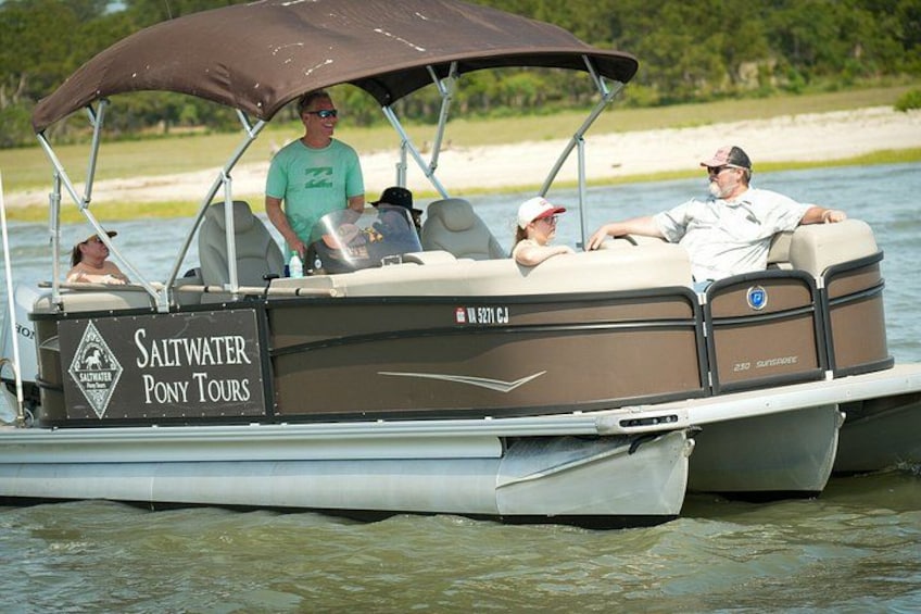 Un bateau doté d’un auvent sur lequel on peut lire : « Saltwater Pony Tours ». 2