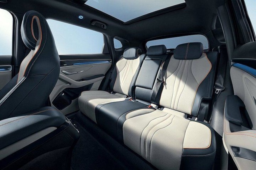 Een auto interieur met zwart en beige leren stoelen, een schuifdak en een middenconsole. 2