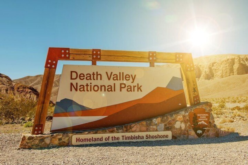 A sign for Death Valley National Park with a landscape illustration and the text 'Homeland of the Timbisha Shoshone.' 1
