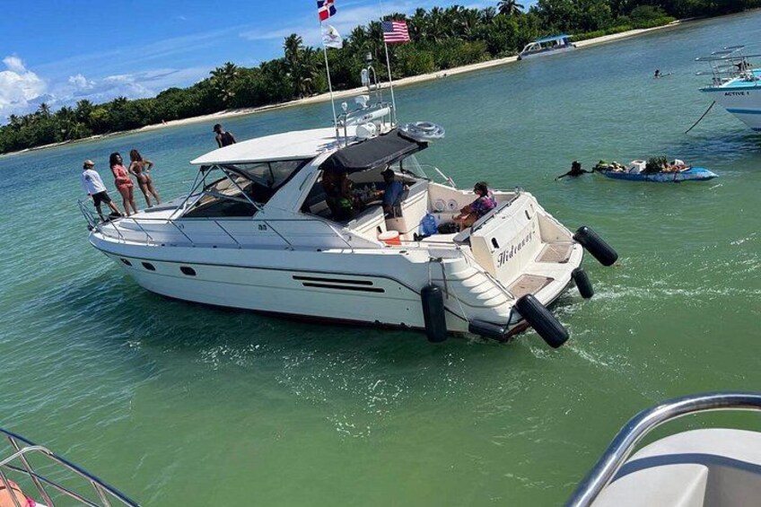 Un velero blanco con gente a bordo, una bandera y un cielo azul despejado. 5