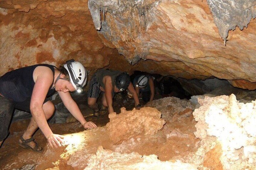 Personas con cascos explorando una cueva con formaciones rocosas. 3
