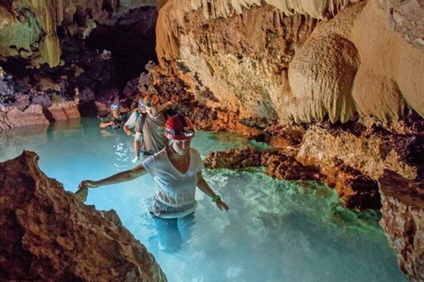 Una persona en una cueva con agua y estalactitas. 1