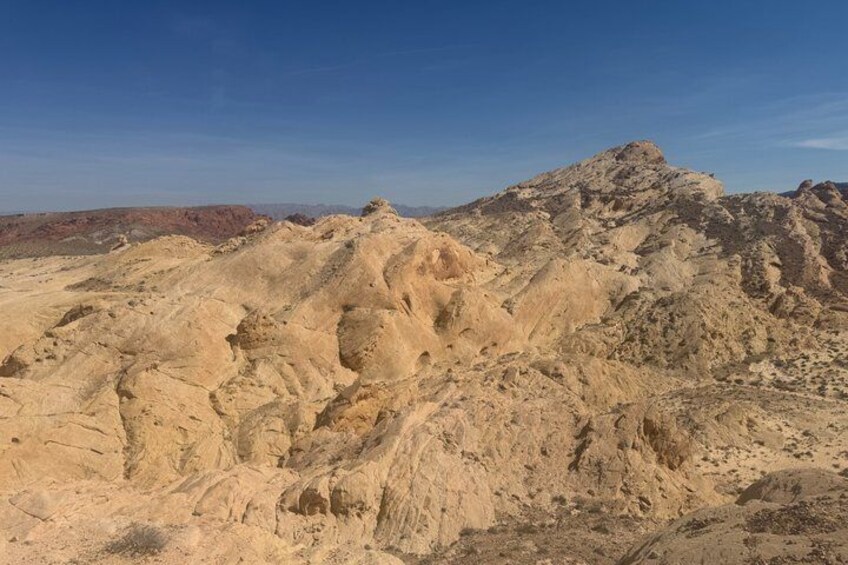 A rugged desert landscape with prominent rock formations and a clear blue sky. 4
