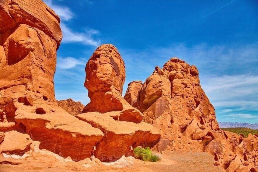 A desert landscape with prominent red rock formations and a clear blue sky. 2