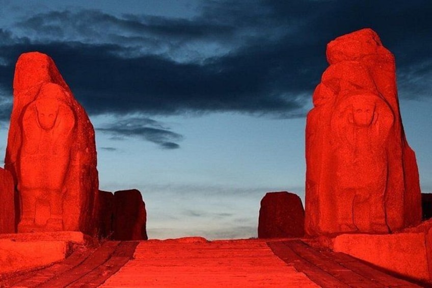 A red rock formation with a pathway leading through it. 5