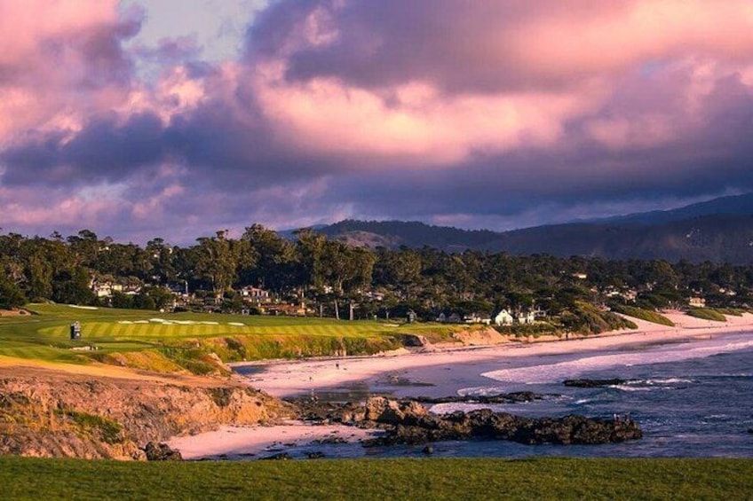 A coastal landscape with a beach, grassy areas, and a golf course. 4