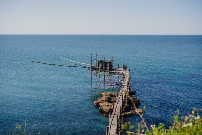 Une jetée qui s’avance dans la mer, avec un bateau amarré à son extrémité. 2