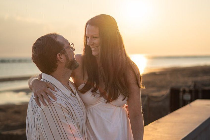 Un couple s’embrasse au coucher du soleil, sur la plage. 1