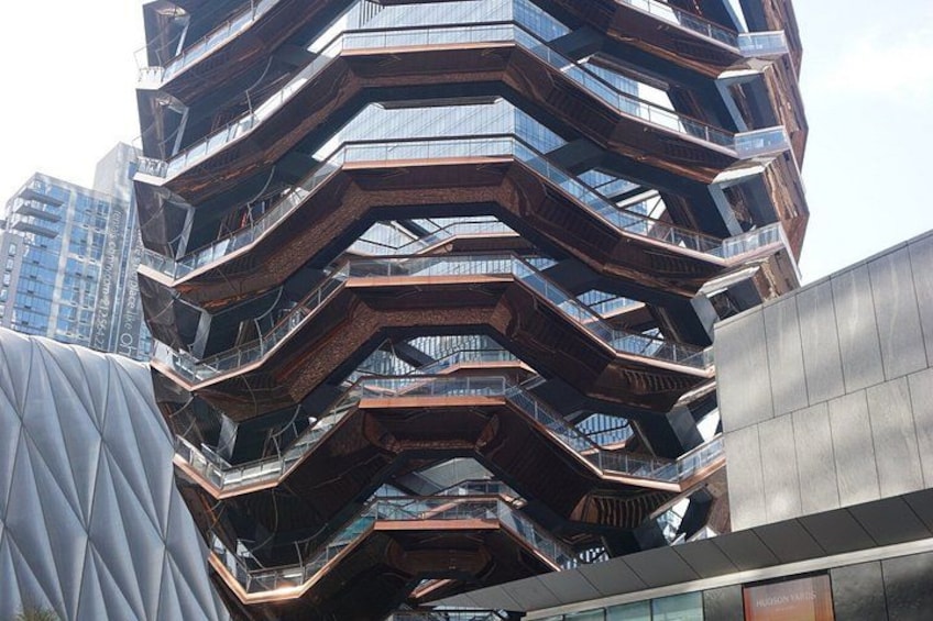 A modern, multi-tiered building with a unique angular design and reflective glass windows. 1