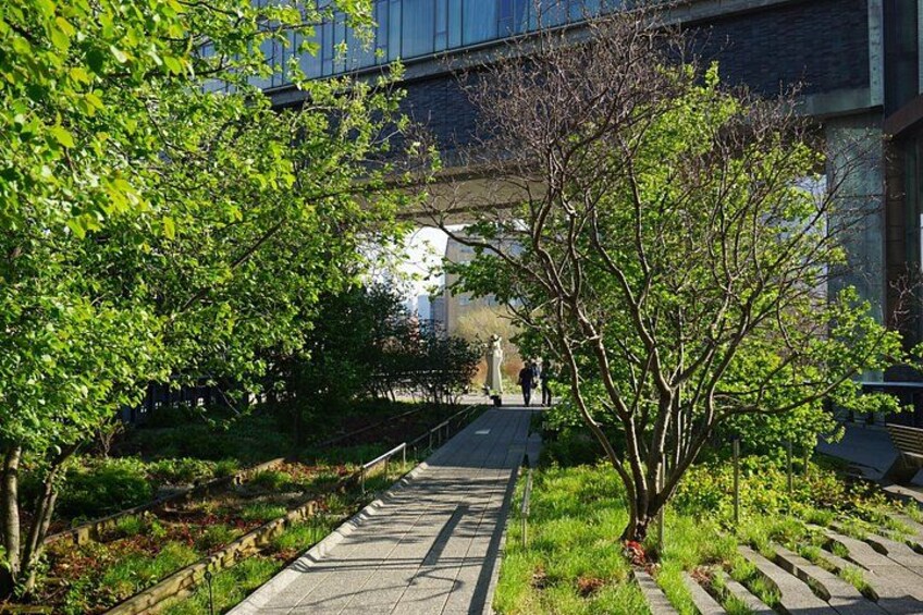 A pathway with trees, a bridge, and a building in the background. 4