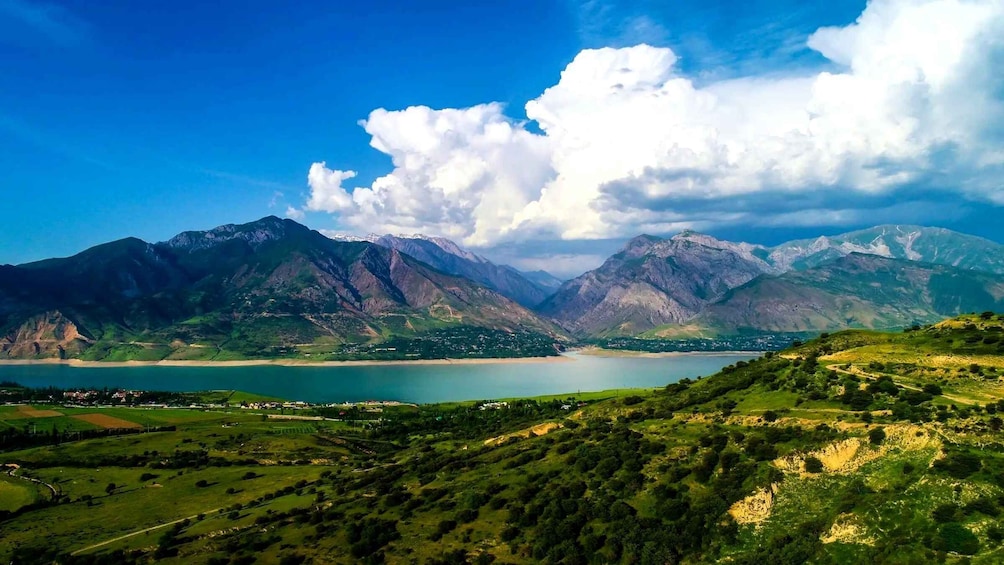 A mountainous landscape with a lake and a small settlement. 1