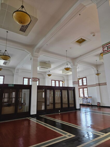 A spacious hall with high ceilings, hanging lamps, and patterned floor tiles. 5