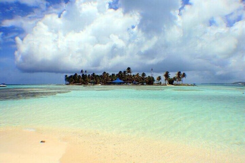 Eine tropische Insel mit klarem türkisblauem Wasser, Sandstrand und Palmen. 4