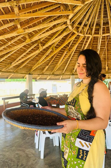 A person holding a large, round, dark-colored tray. 1