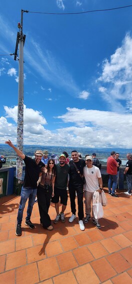 A group of people on a terrace with a view of the landscape. 4