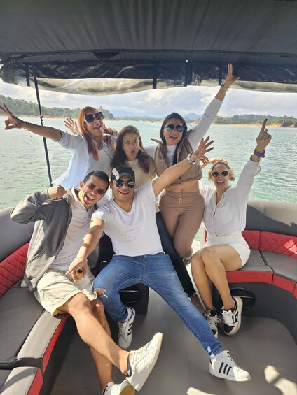 A group of people on a boat with a body of water and distant land in the background. 1