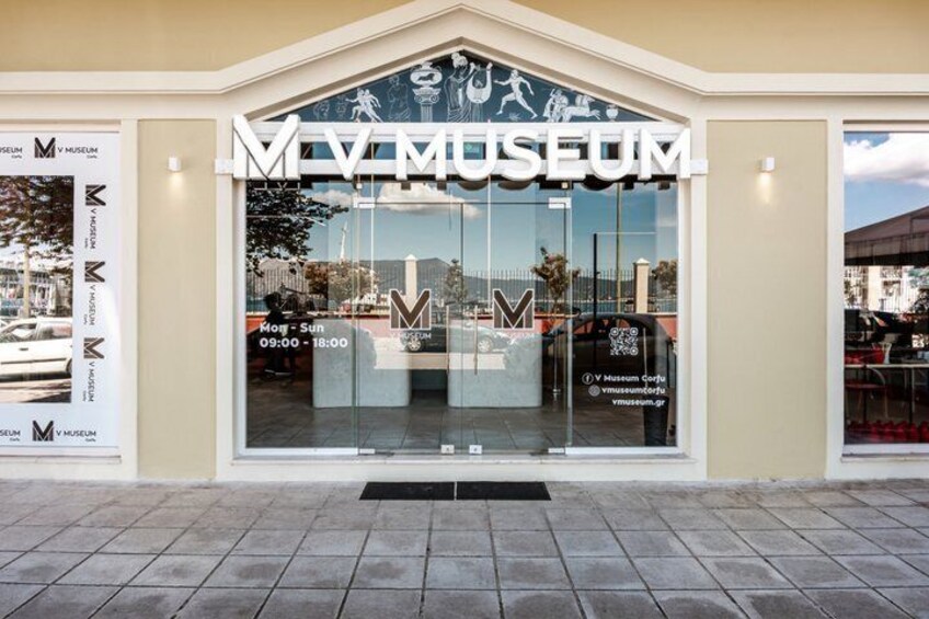L’entrée du musée MV, avec sa façade en verre transparent, son sol carrelé et une montagne en arrière-plan. 1