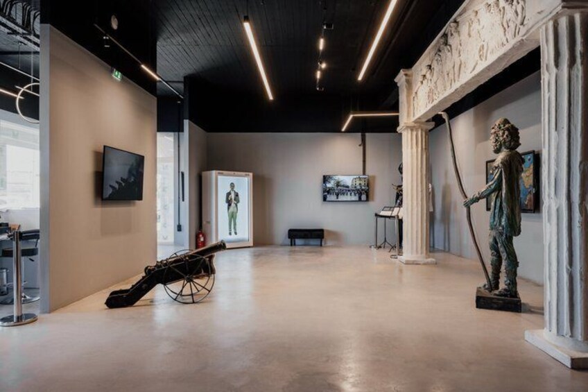 Une galerie d’art où l’on peut admirer des sculptures, un piano et un grand tableau accroché au mur. 4