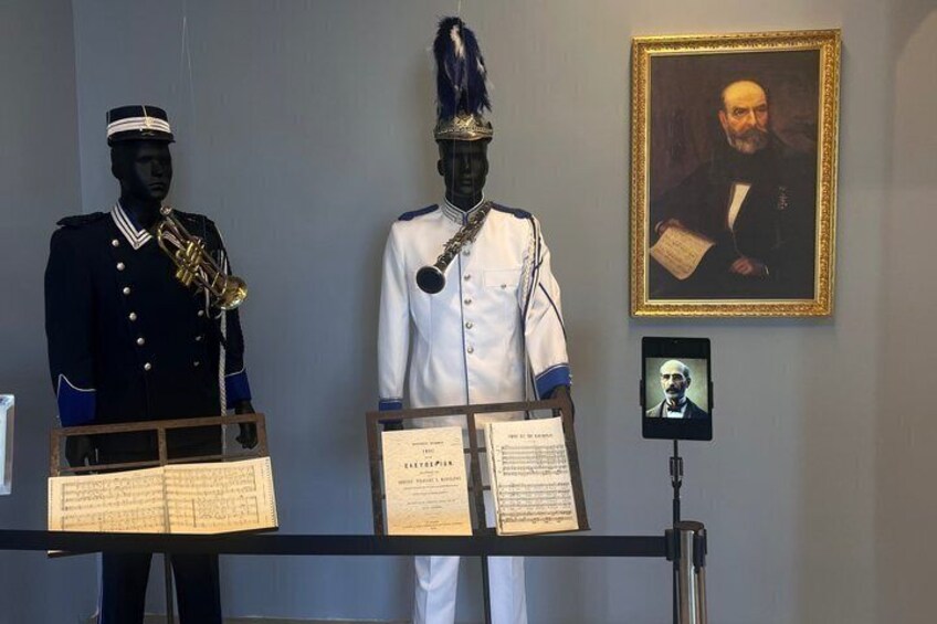 Deux mannequins vêtus d’uniformes militaires, un portrait encadré et une tablette affichant un portrait. 3