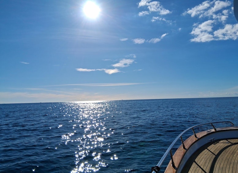 A boat on a calm sea with sunlight reflecting off the water. 4