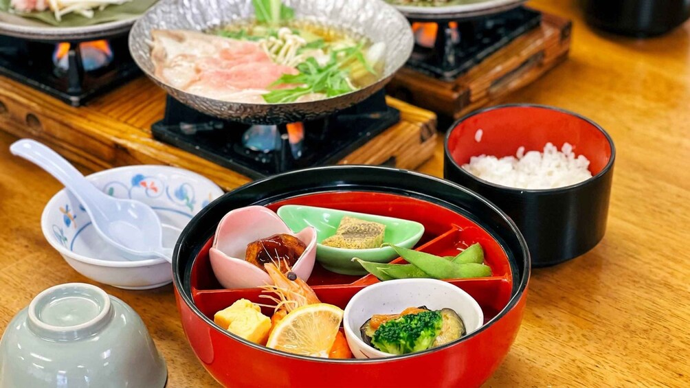 A traditional Japanese meal setup with a hot pot, rice, and various side dishes. 4