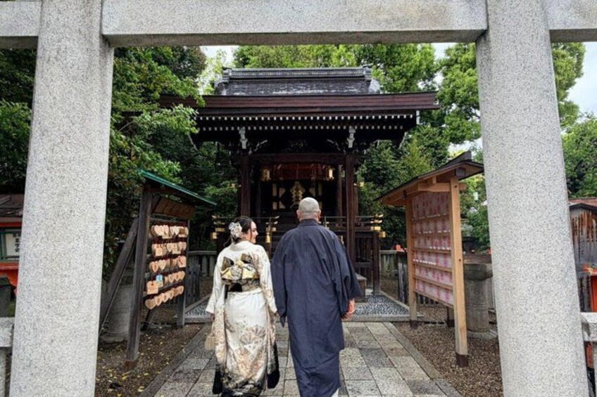 A traditional Japanese torii gate with a couple walking through it. 3