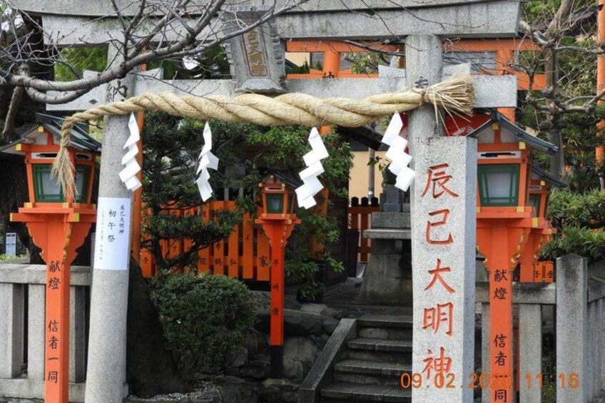 A traditional Japanese torii gate with orange pillars and white decorations. 2