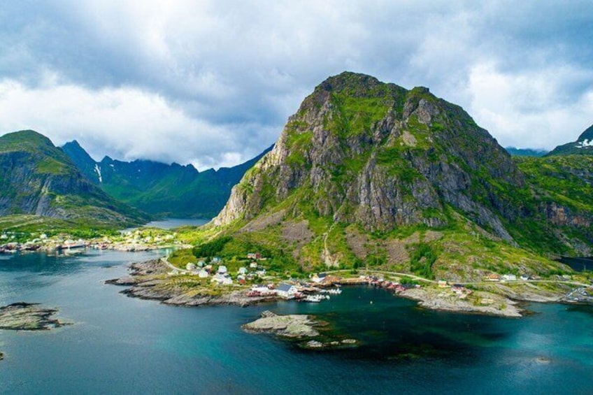 A coastal village with houses near the water, surrounded by mountains. 1