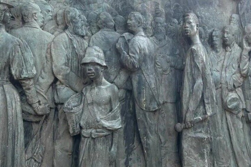 Ein großes steinernes Relief, das eine Gruppe von Menschen in historischer Kleidung zeigt. 2