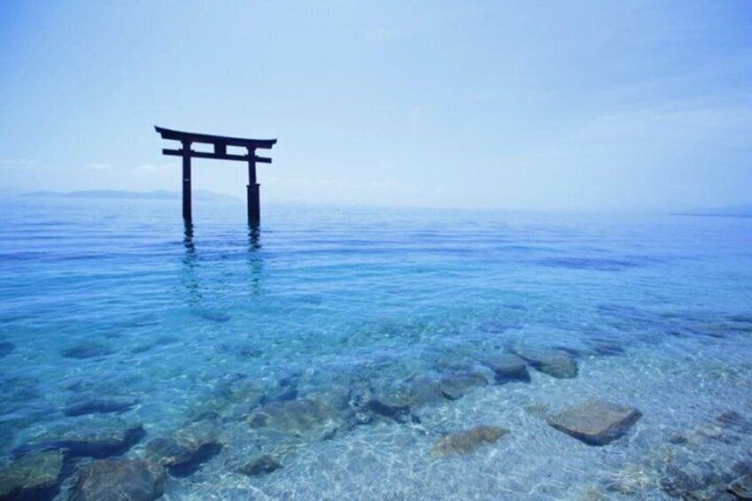 En torii-port i klart vand med synlige sten. 1