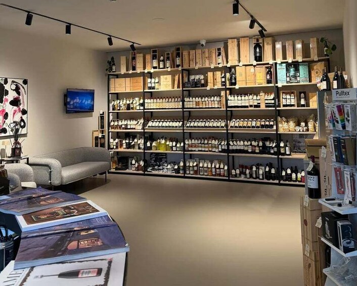 A modern retail space with shelves of bottled beverages and a television on the wall. 1