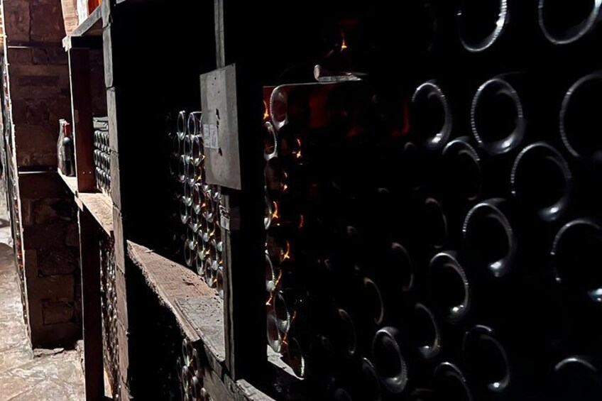 Una cantina vinicola con file di bottiglie e una scaffalatura in legno. 2