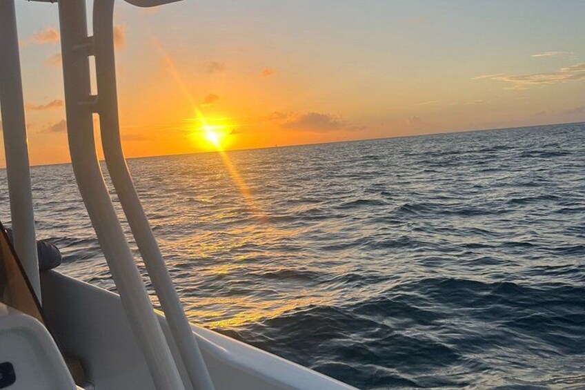 A sunset over the ocean with a boat in the foreground. 2