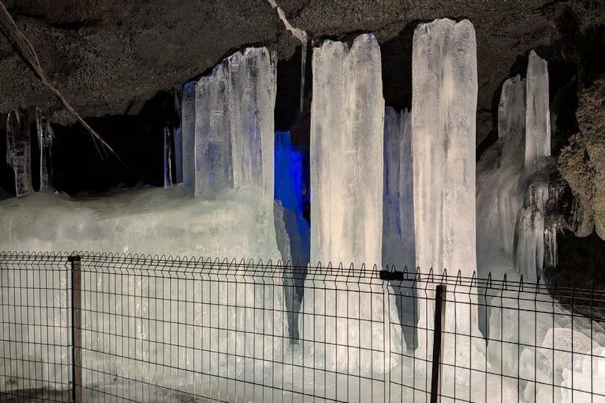 Una cueva con formaciones de hielo y un área cercada. 2