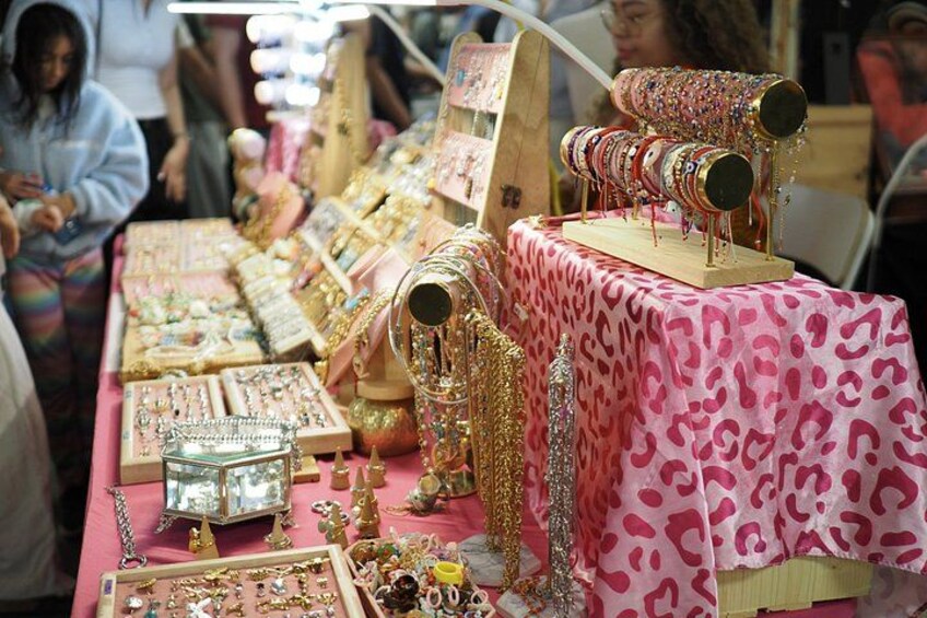 A jewelry stall with various items on display, including necklaces, bracelets, and rings. 5